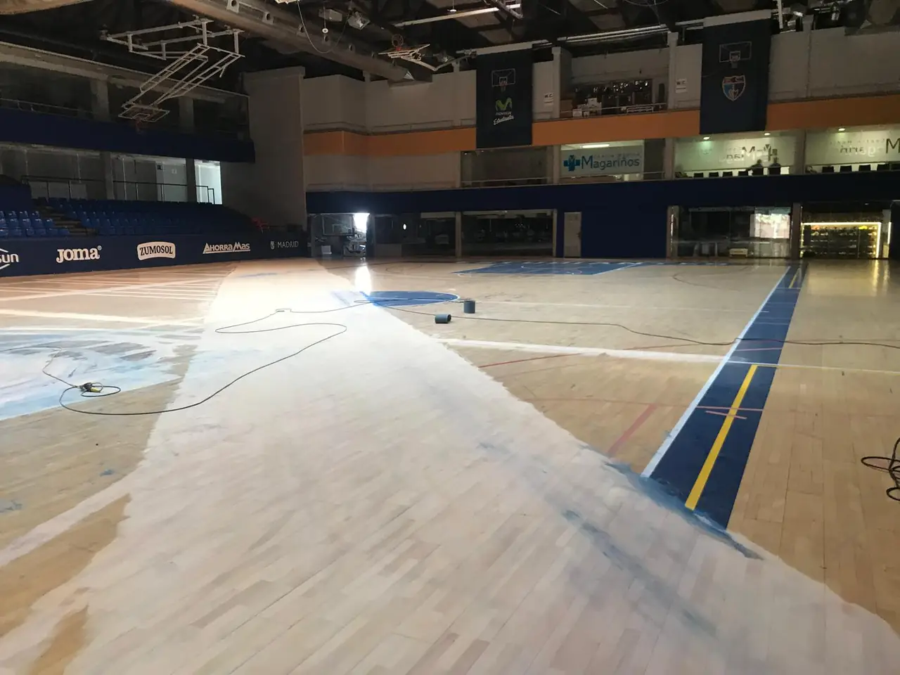 La misma cancha durante el lijado del suelo de madera
