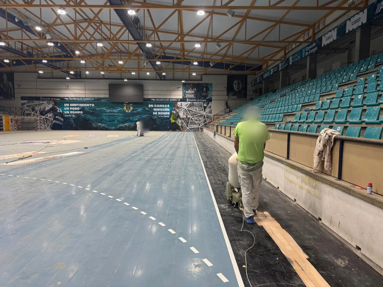La misma pista antes de la renovación, con el pavimento azul desgastado y el lijado en marcha